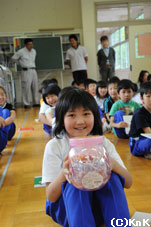 ロクシタン・ジャパンからもらったお菓子を 手にする釜石市立栗林小学校の児童