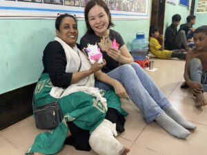 シャミマと岡田。子どもたちが作ってプレゼントしてくれた折り紙を手に。